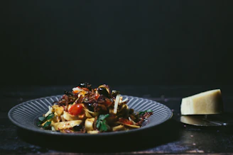 A colorful plate of traditional Sicilian caponata with fresh herbs and olives.