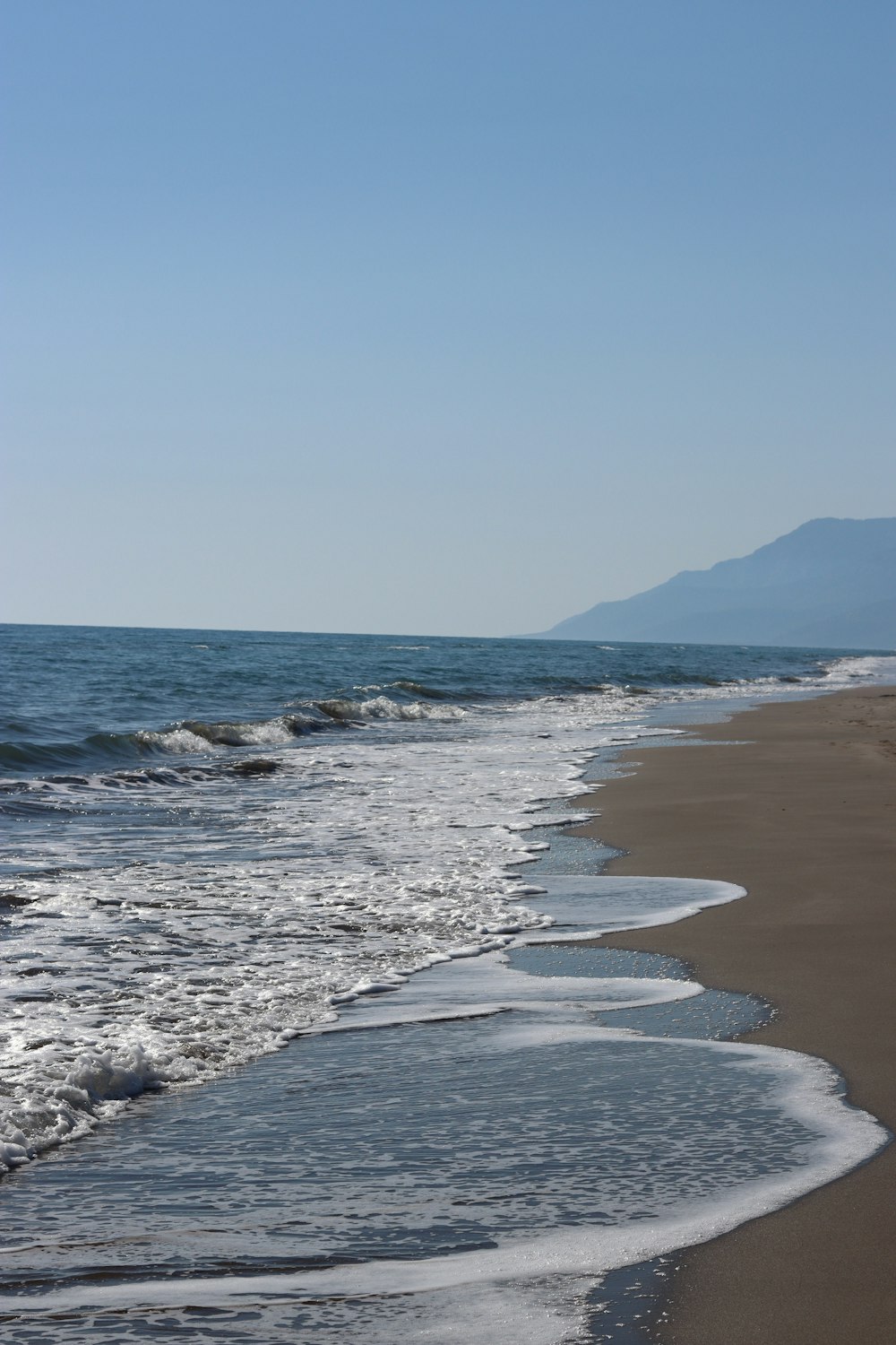 ocean waves crashing on shore during daytime