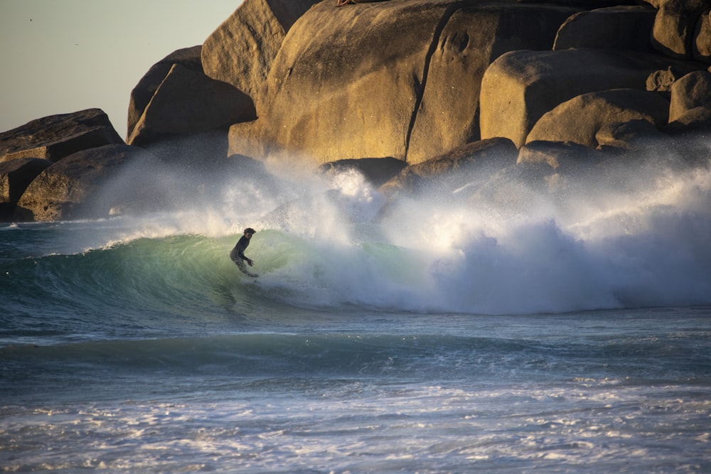 Persona surfeando sobre las olas del mar durante el día