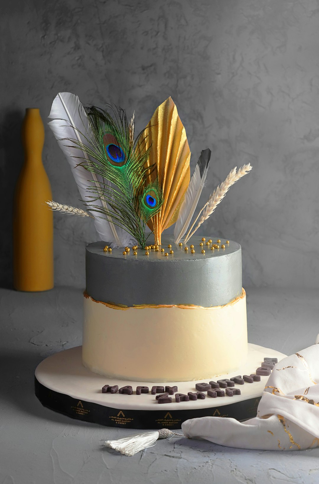 yellow and black cake with blue and yellow feather accent