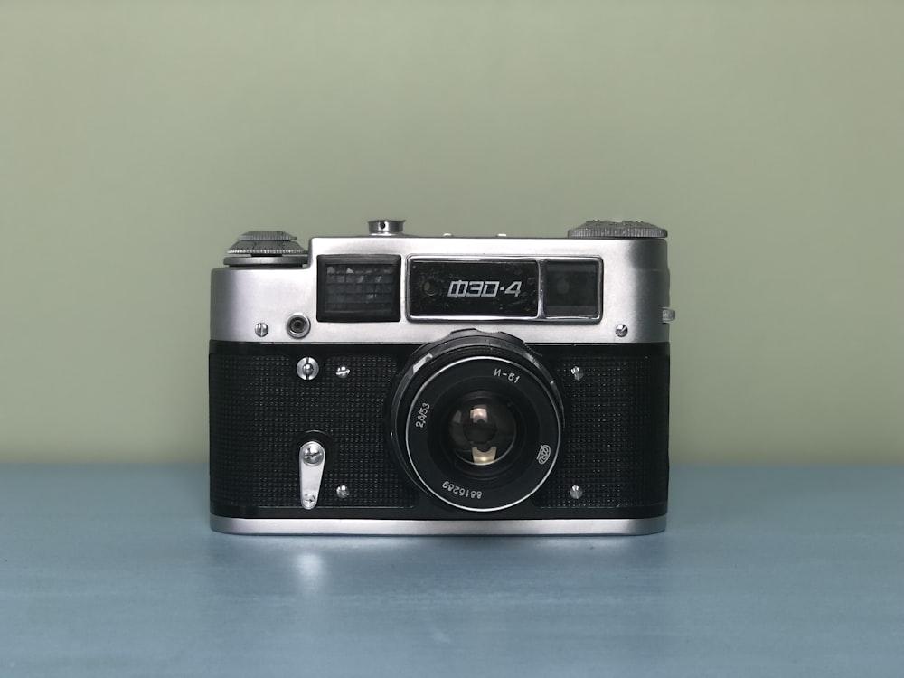 black and silver camera on blue table