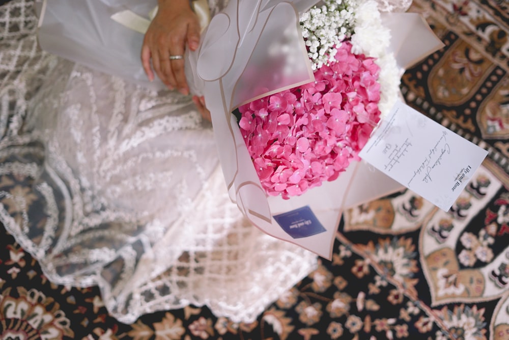 pink and white bouquet on white textile