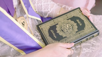 person holding green and white book
