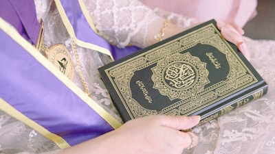 person holding green and white book