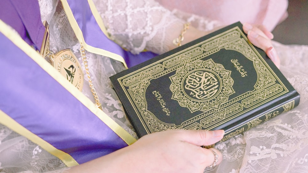 person holding green and white book