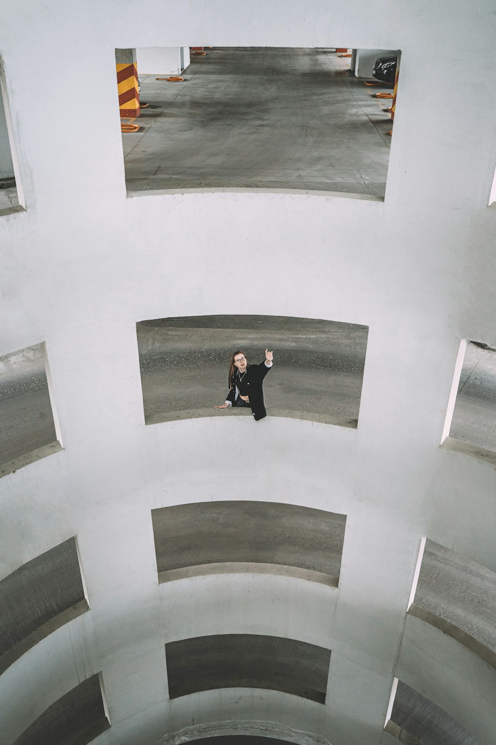 man in black jacket and pants standing on black and white wall