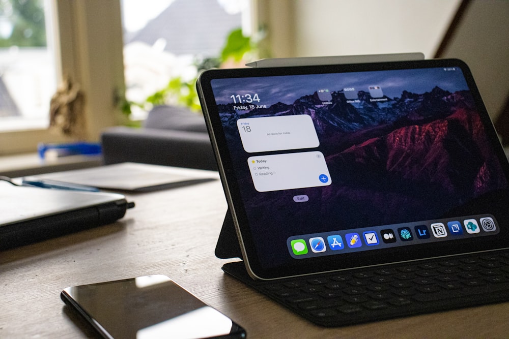 Schwarzes iPad auf braunem Holztisch