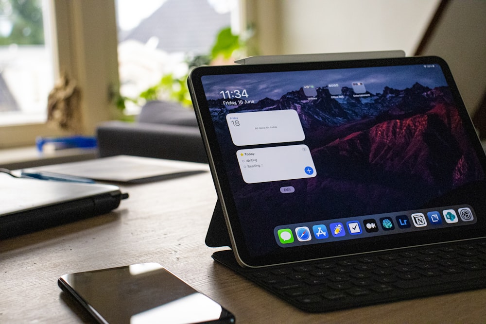 black ipad on brown wooden table