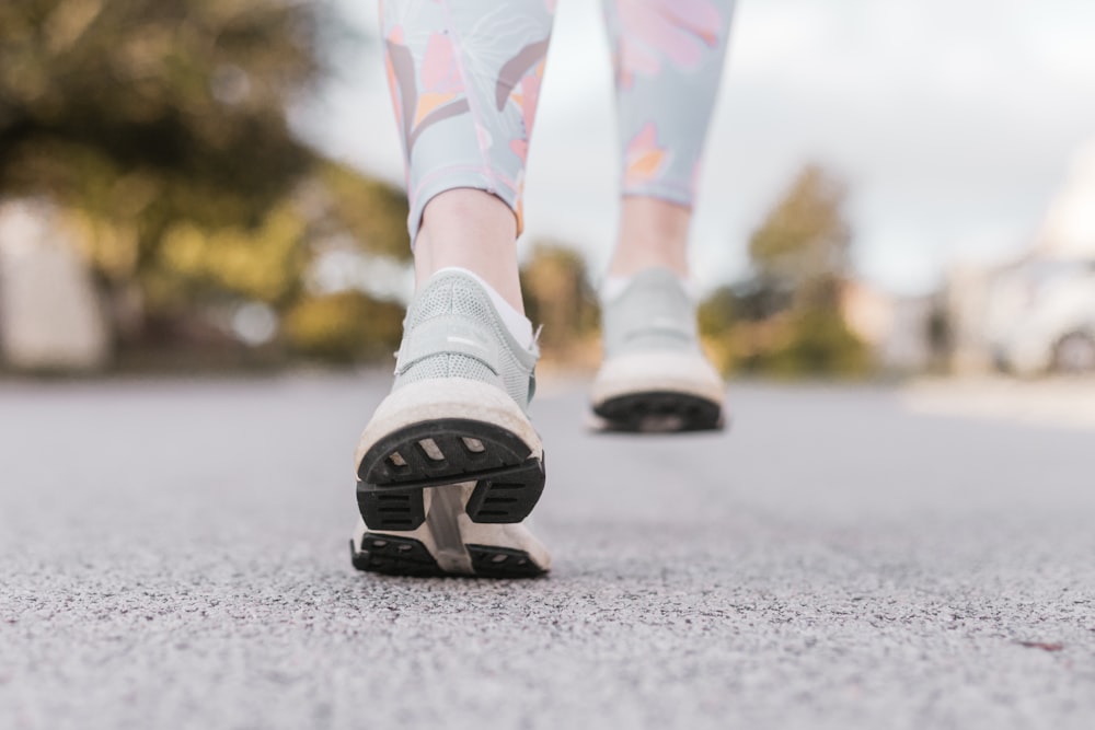 Person in weißen und schwarzen Nike-Schuhen