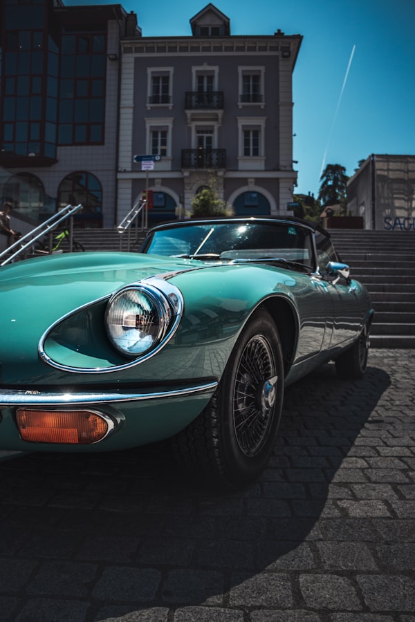 Green performance coupe near a modern building