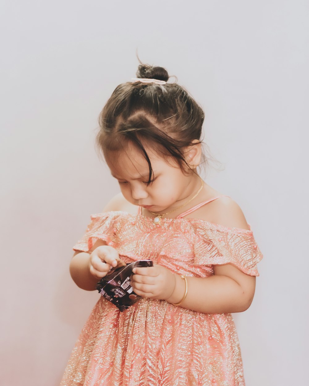 girl in white and red dress holding black and white toy car