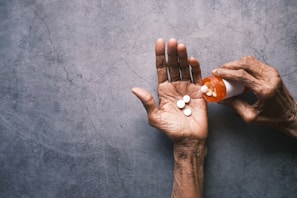 person holding white round pills