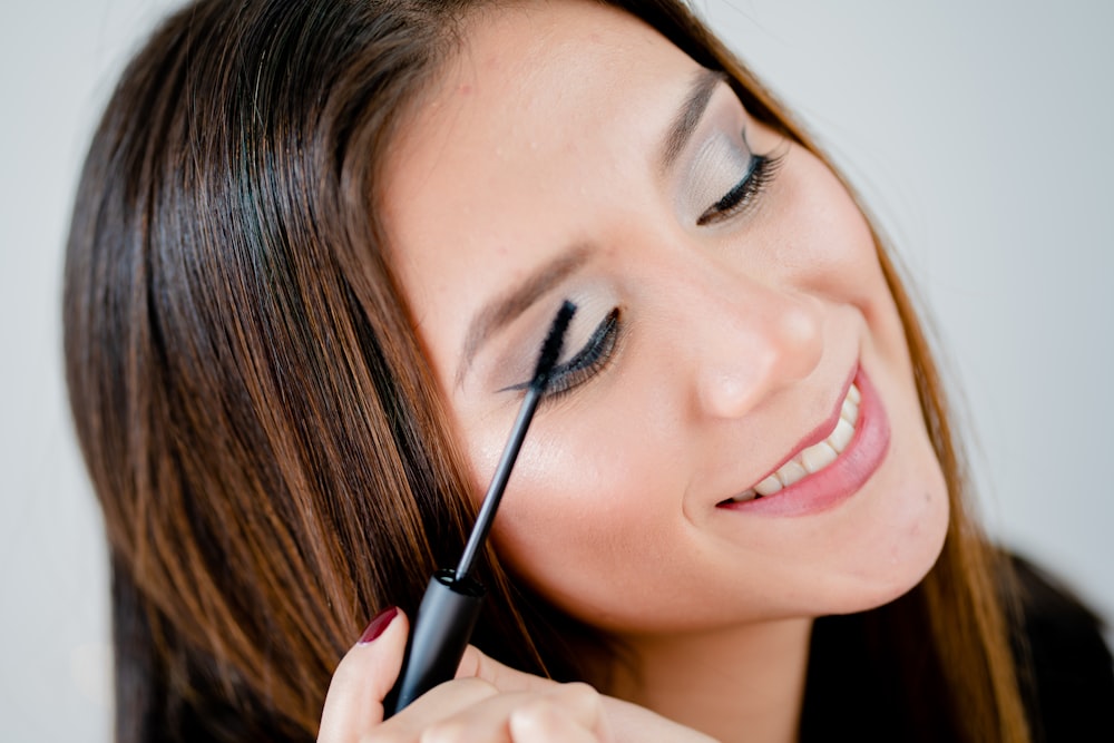 woman holding black pen smiling