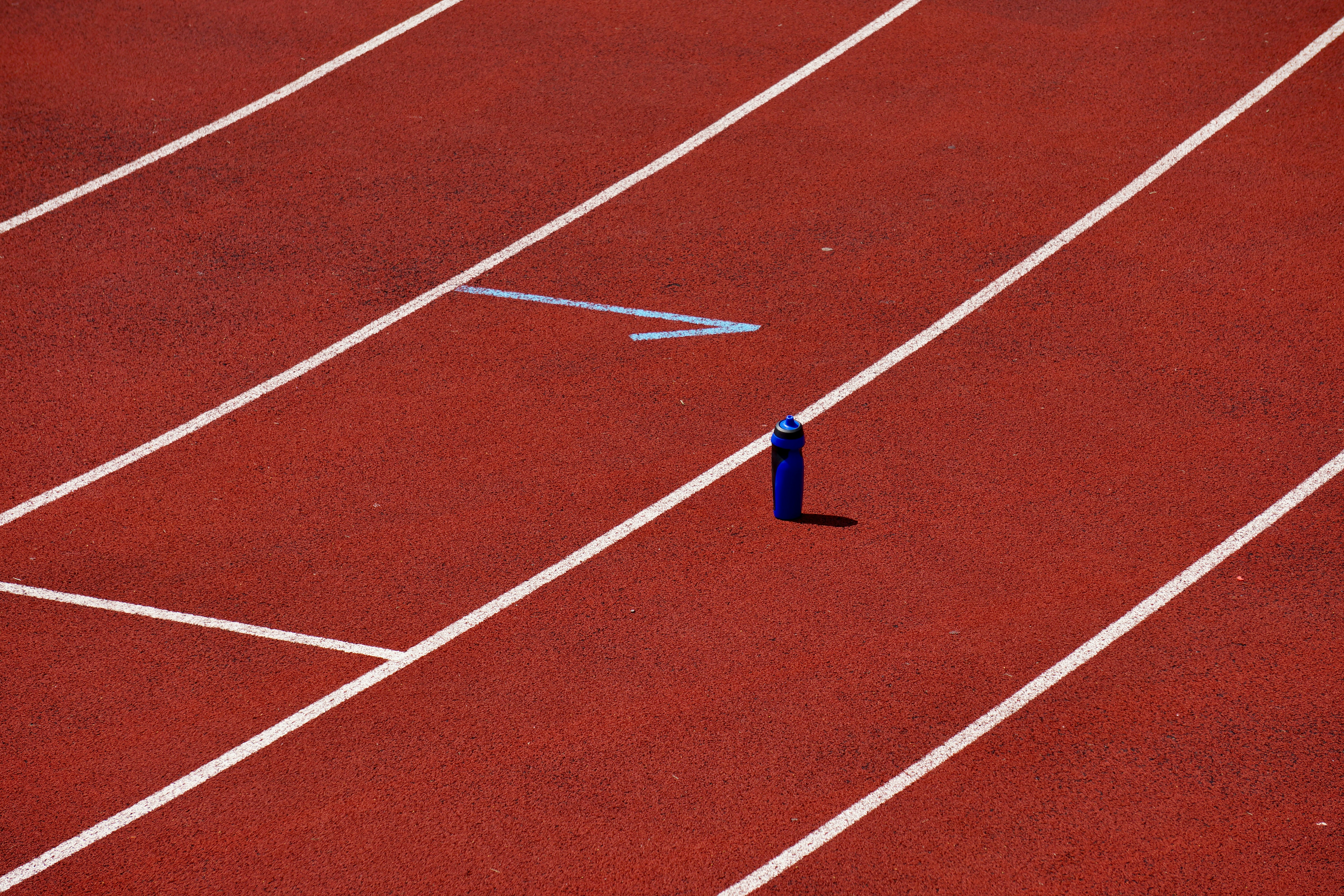 茶色と白の陸上競技場に青い糸の写真 Unsplashで見つけるハードライトの無料写真