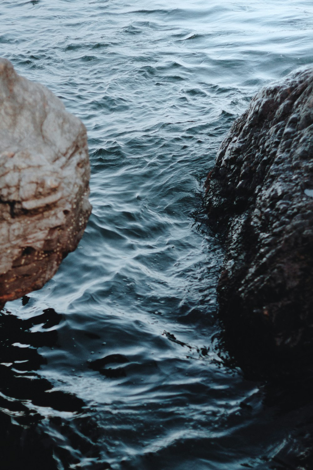 brown rock formation on body of water during daytime