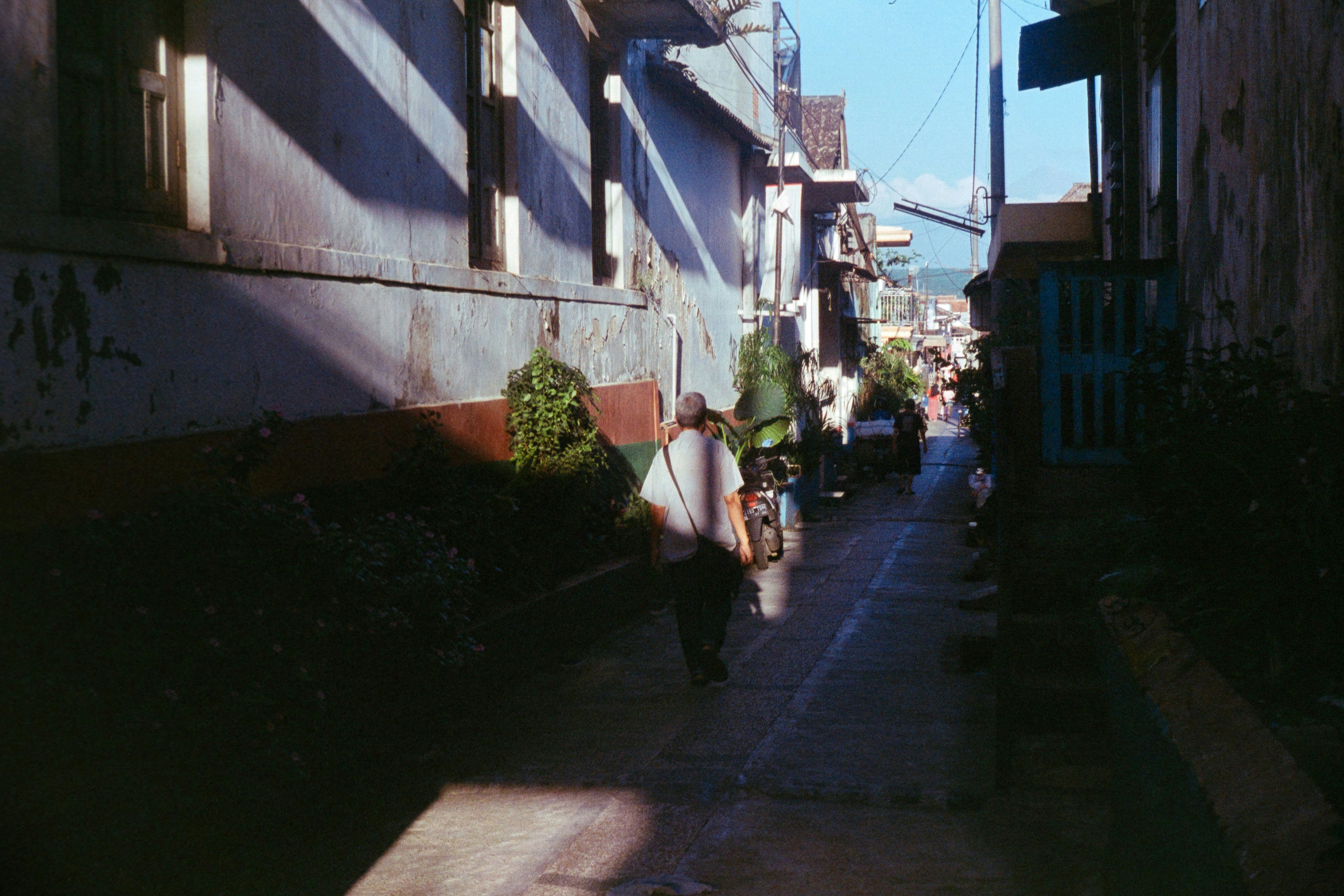 woman in black jacket walking on sidewalk during daytime