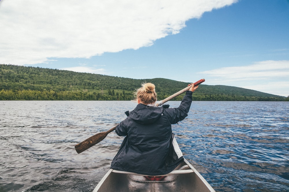 woman in black jacket riding on boat during daytime