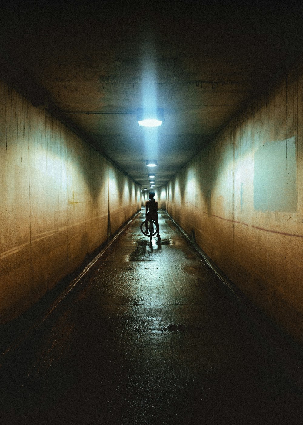 man in black jacket walking on tunnel