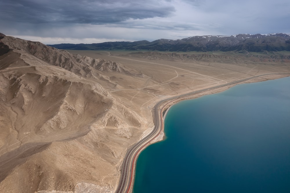 Luftaufnahme der braunen und grauen Berge am blauen Meer während des Tages