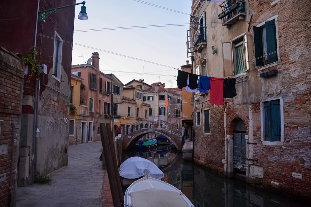 blue boat on river between buildings during daytime