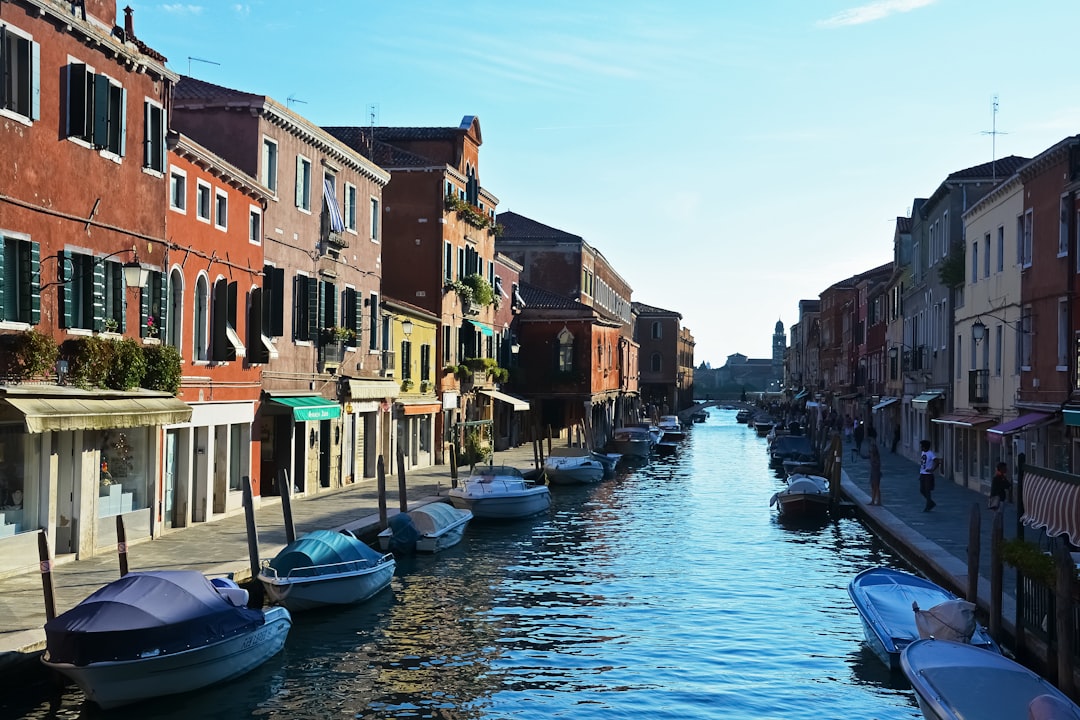 blue boat on river between houses during daytime