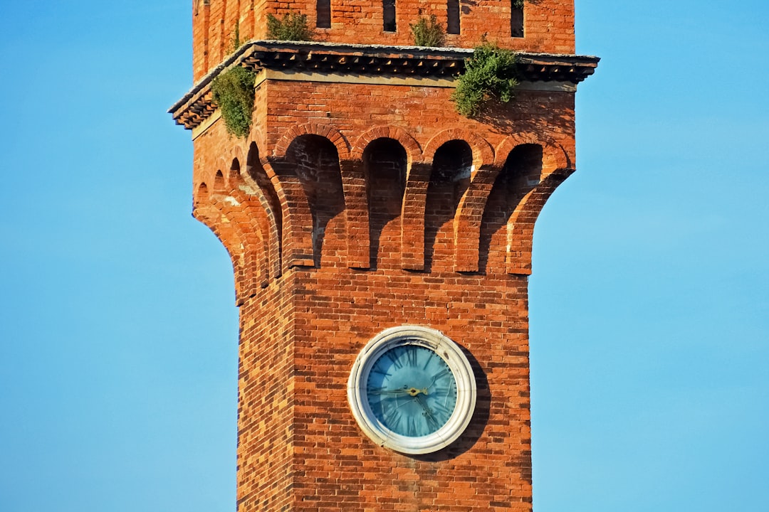 brown brick tower with analog clock