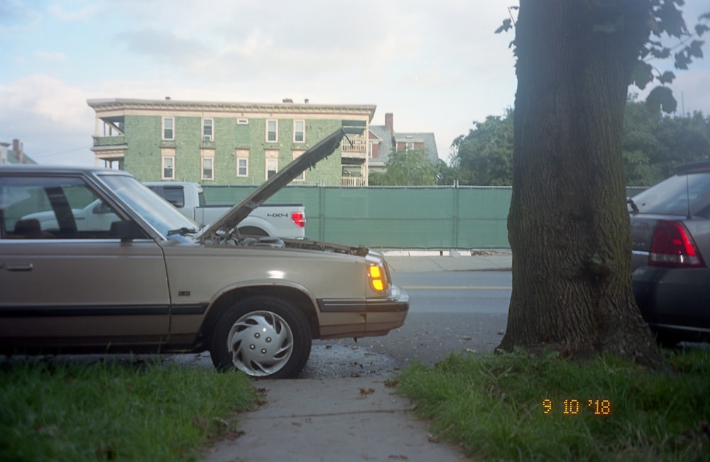 silver sedan parked on sidewalk during daytime