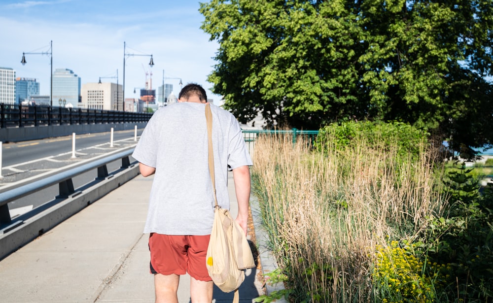 woman in white t-shirt and orange skirt standing on sidewalk during daytime