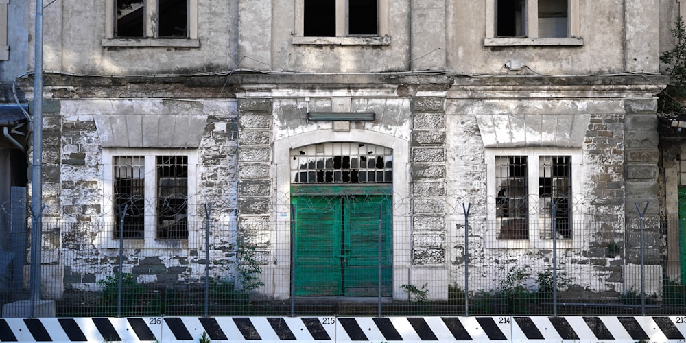 white concrete building with green wooden door