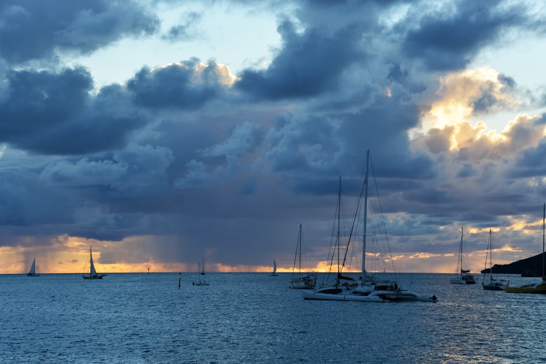 white sail boat on sea under cloudy sky during daytime