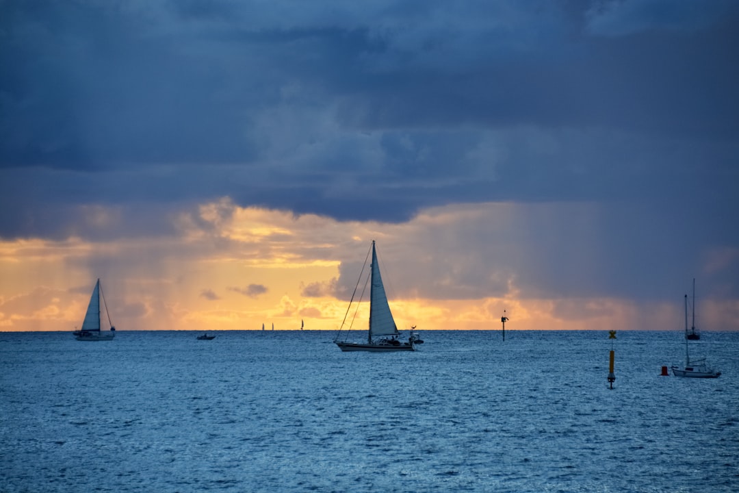 sailboat on sea under gray clouds