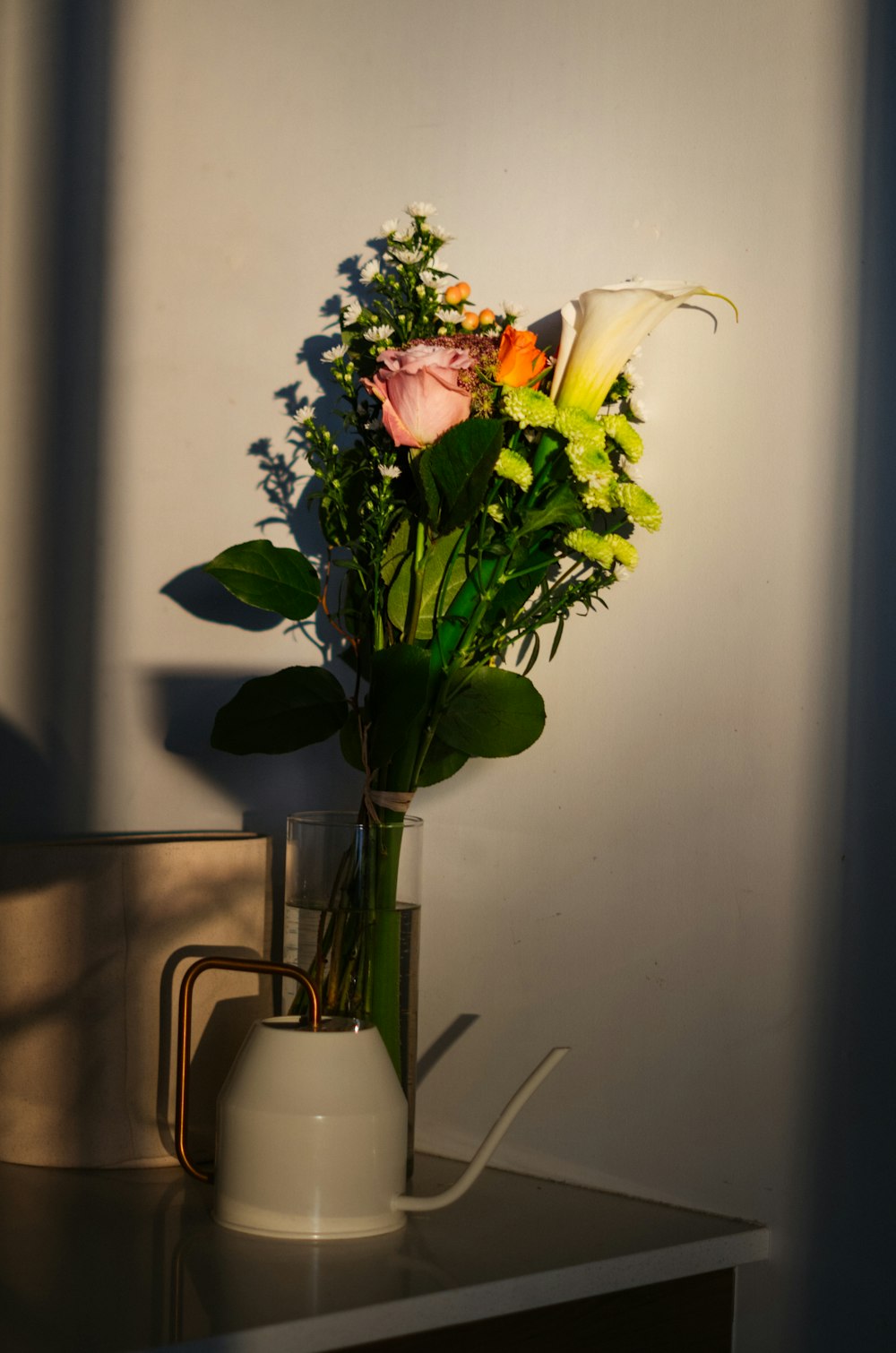 white and pink roses in white ceramic vase