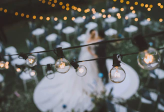 A rustic outdoor wedding scene with emerald green and dusty rose decorations under soft natural light.