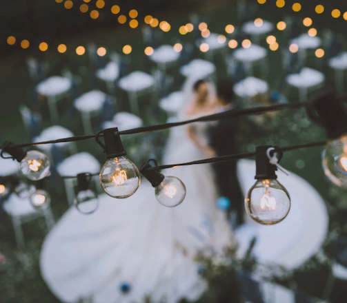 A rustic outdoor wedding scene with emerald green and dusty rose decorations under soft natural light.