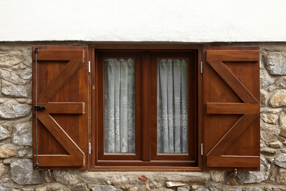 Fenêtre en bois marron sur mur blanc
