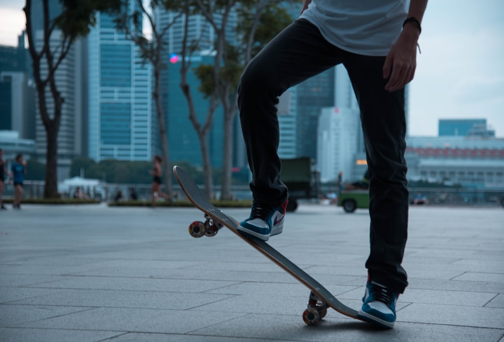 man in white shirt and black pants riding skateboard