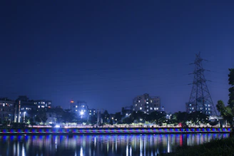 Nighttime cityscape illuminated by reliable power infrastructure, reflecting community transformation.