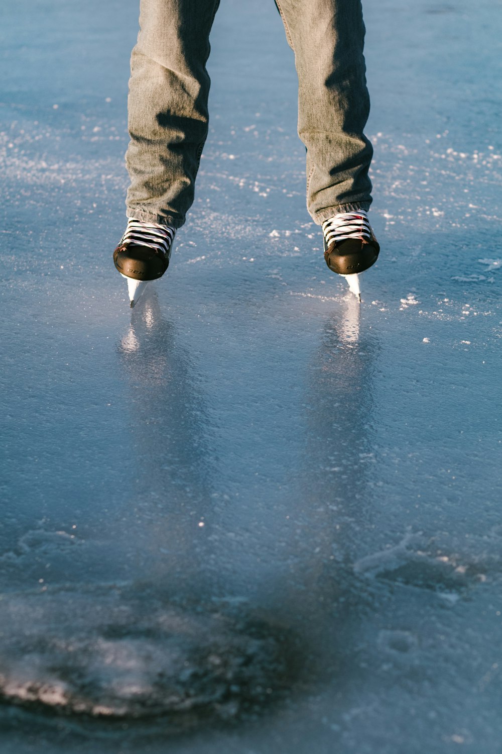 person in black pants and black boots standing on wet floor