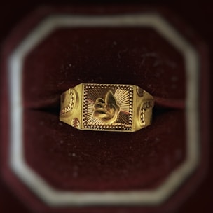 Finished custom gold ring with intricate detailing displayed on black velvet.