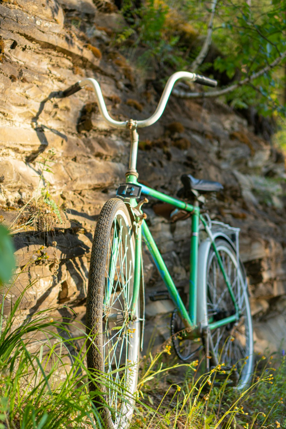 teal city bike on brown rock