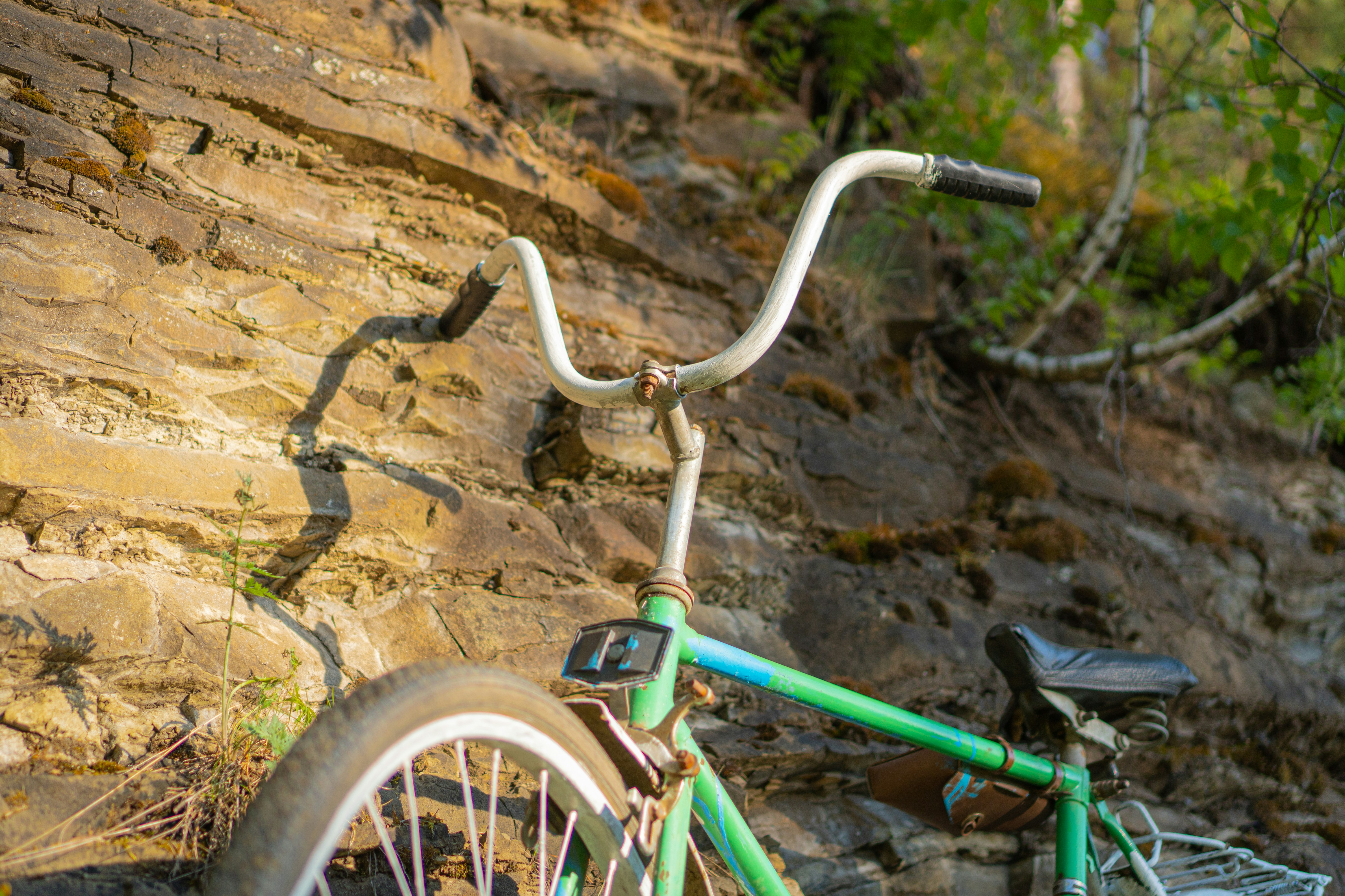green and white bicycle on brown rock