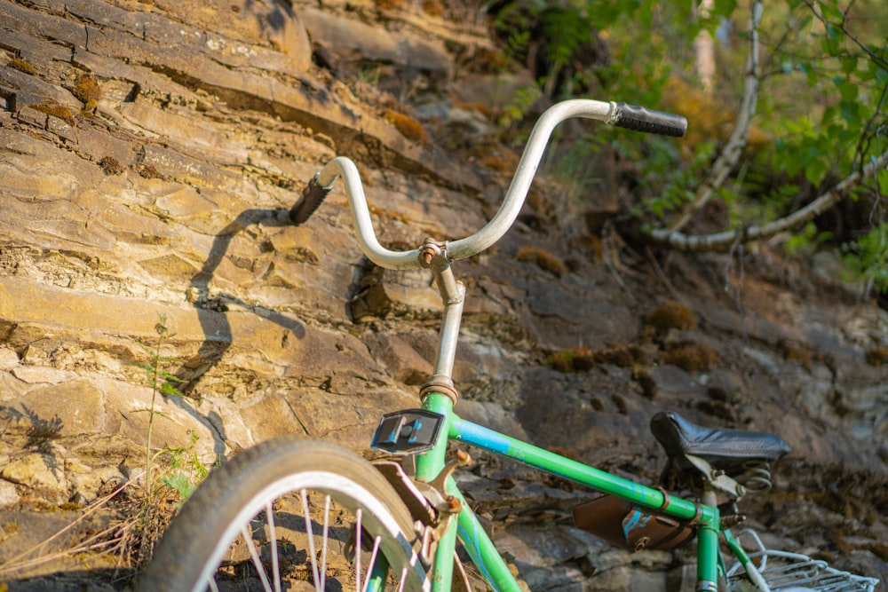 green and white bicycle on brown rock