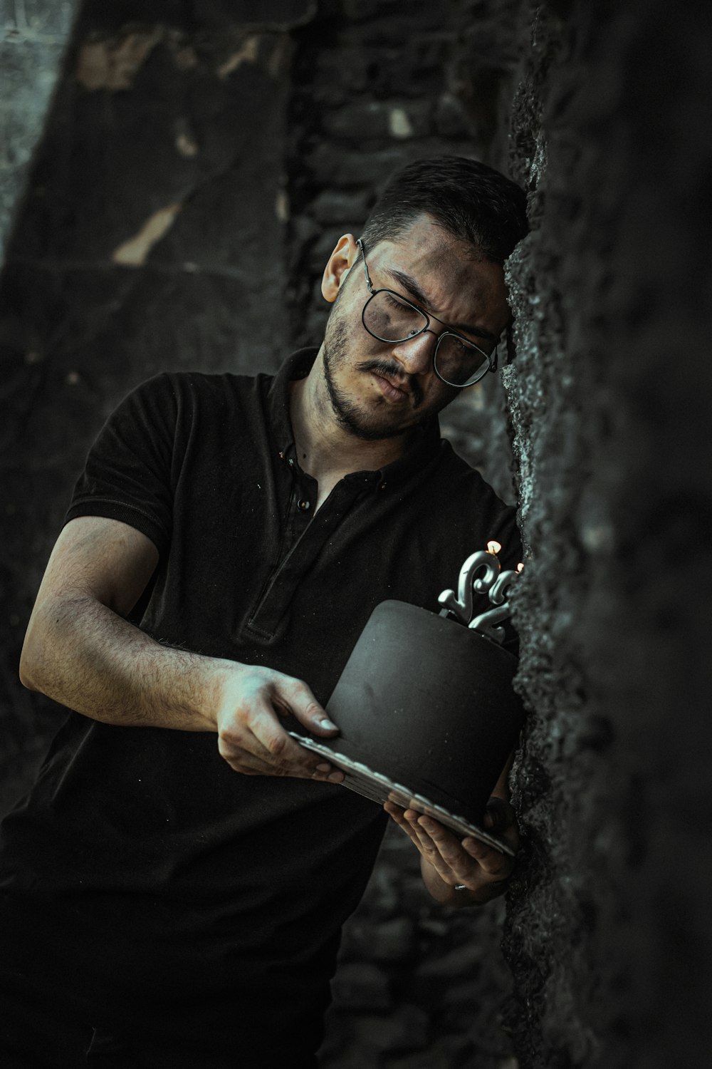 Mann im schwarzen Poloshirt mit schwarzem Keramikbecher
