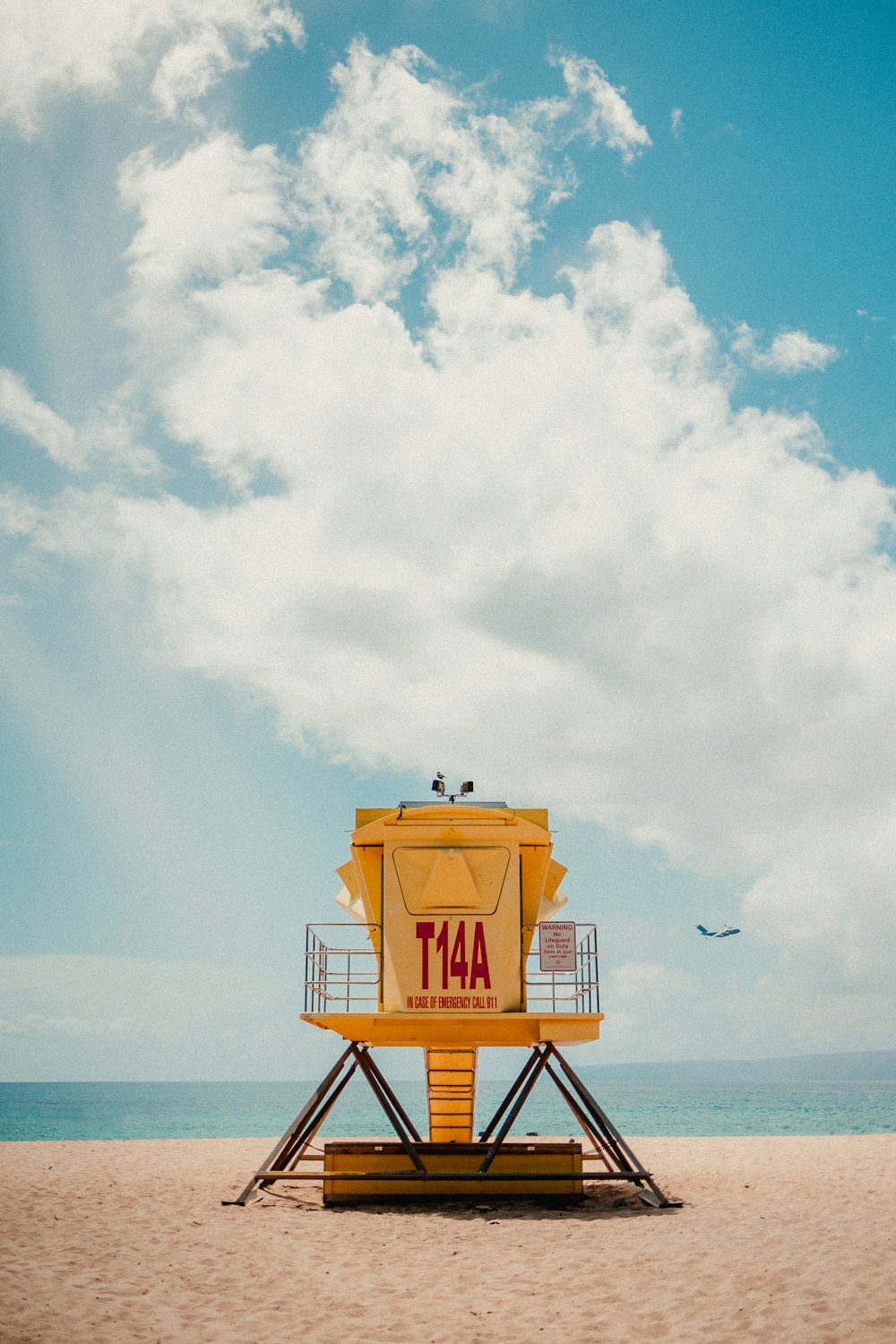 Torre di salvataggio arancione e nera sulla spiaggia durante il giorno