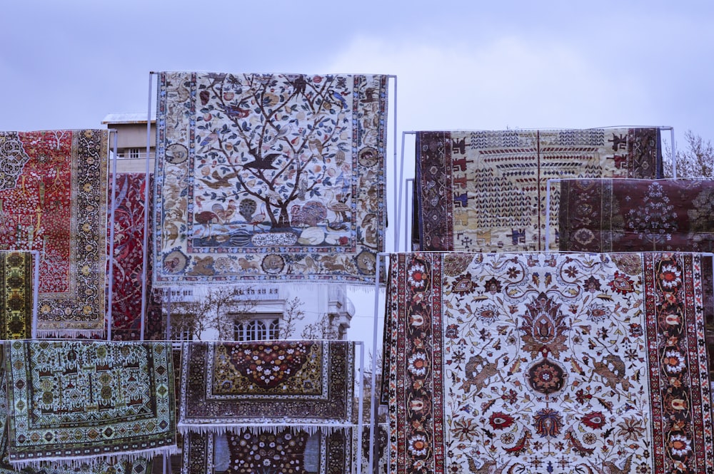 a bunch of rugs that are hanging up