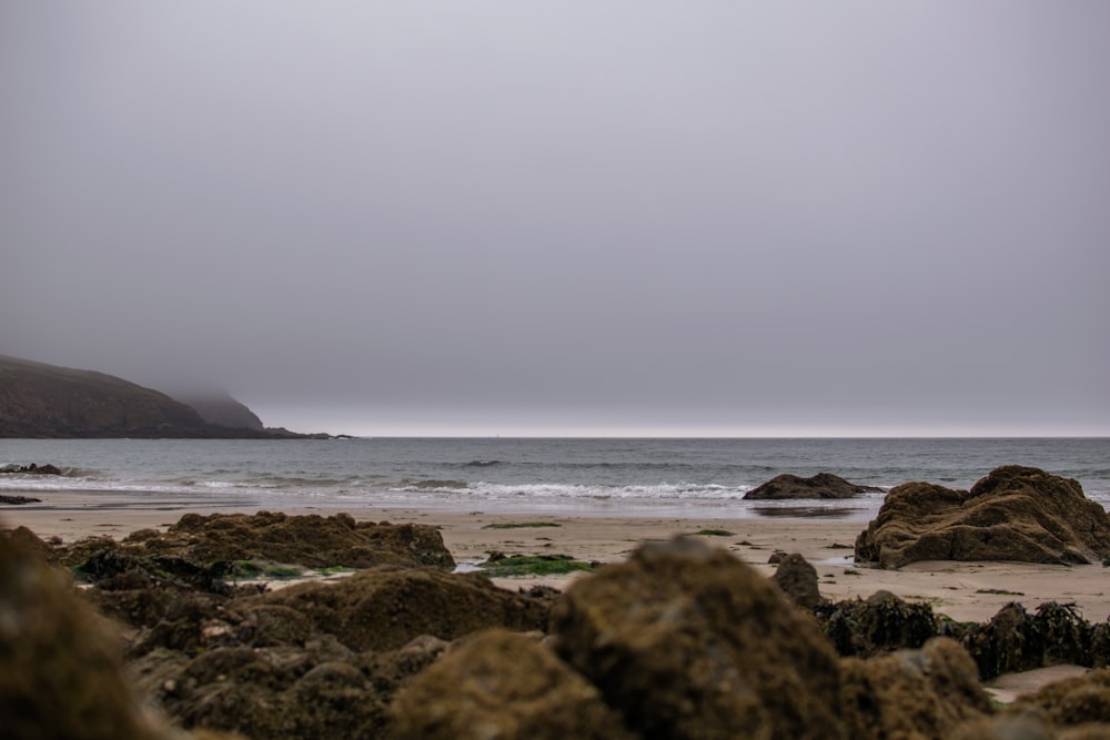 body of water near brown rock formation during daytime