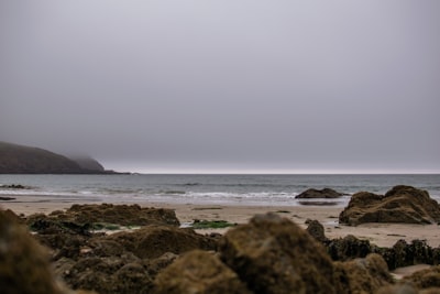 body of water near brown rock formation during daytime plymouth google meet background