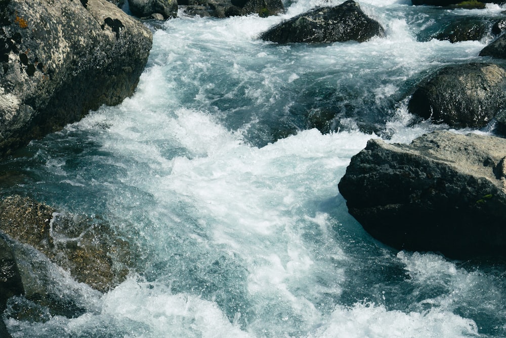 water waves hitting rocks during daytime