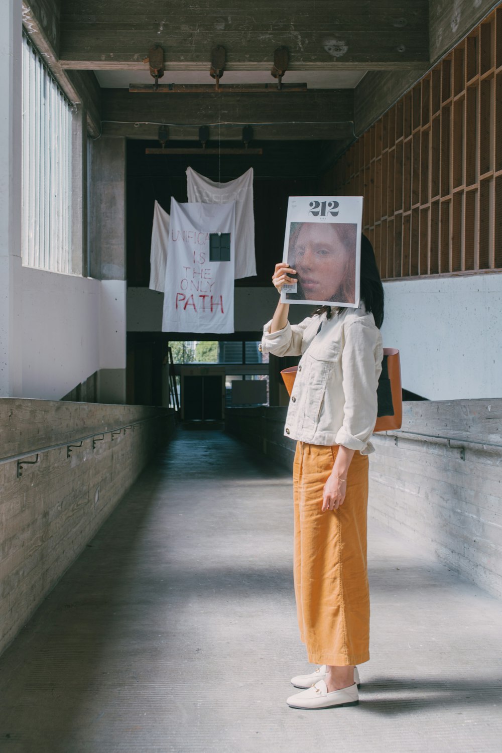 woman in white robe standing on gray concrete floor