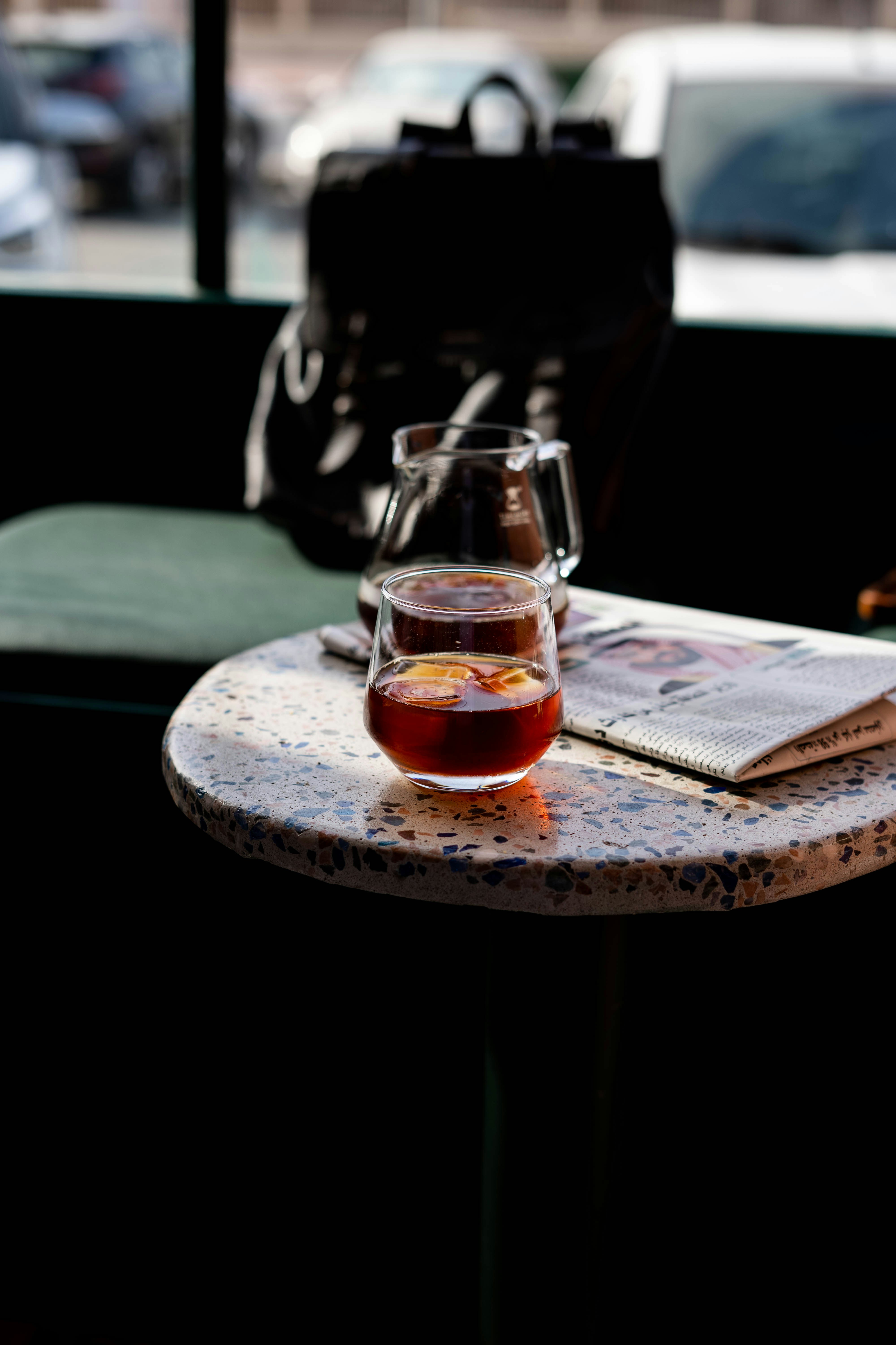 clear glass mug with brown liquid on brown wooden table